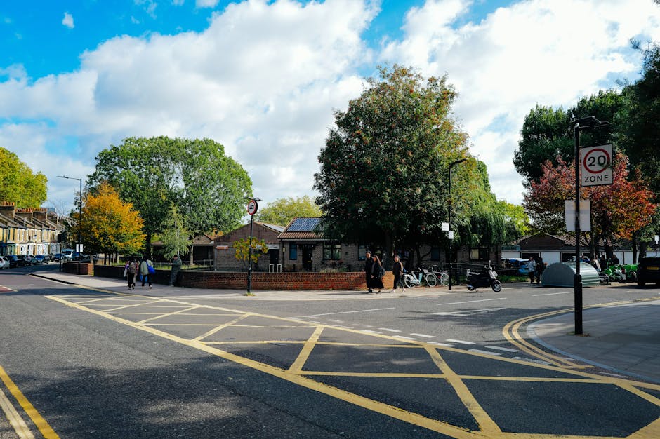A view of a busy street corner in Wood Green with a large, white corner building featuring multiple windows and decorative architectural details. The ground level of the building hosts a pub named 'Th