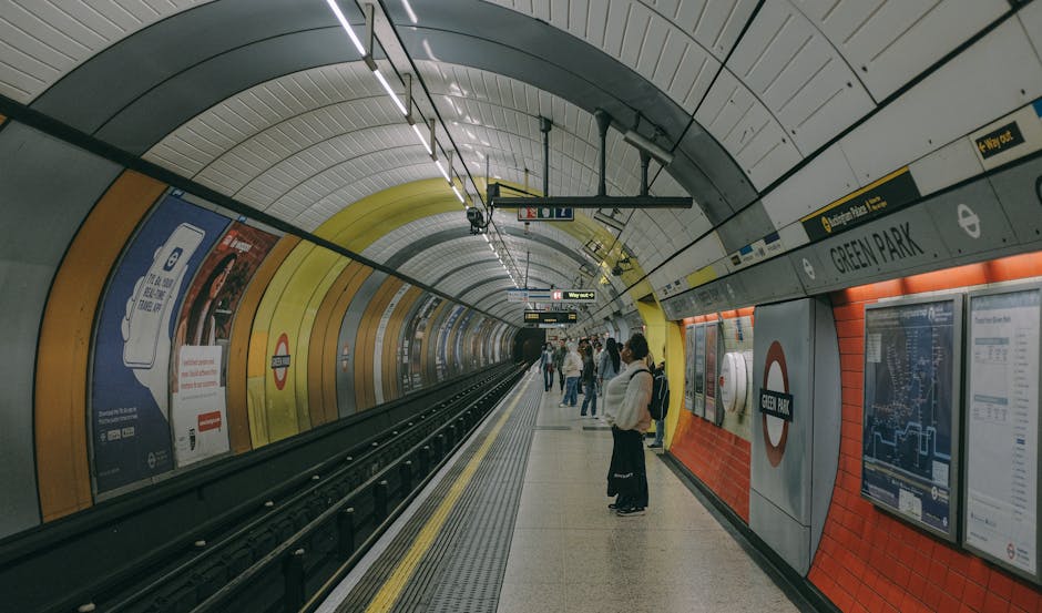 The exterior of the Moor Park entrance to the underground station, featuring a blue sign with white lettering. In front of the entrance, there is a wooden bench with metal armrests positioned on the p